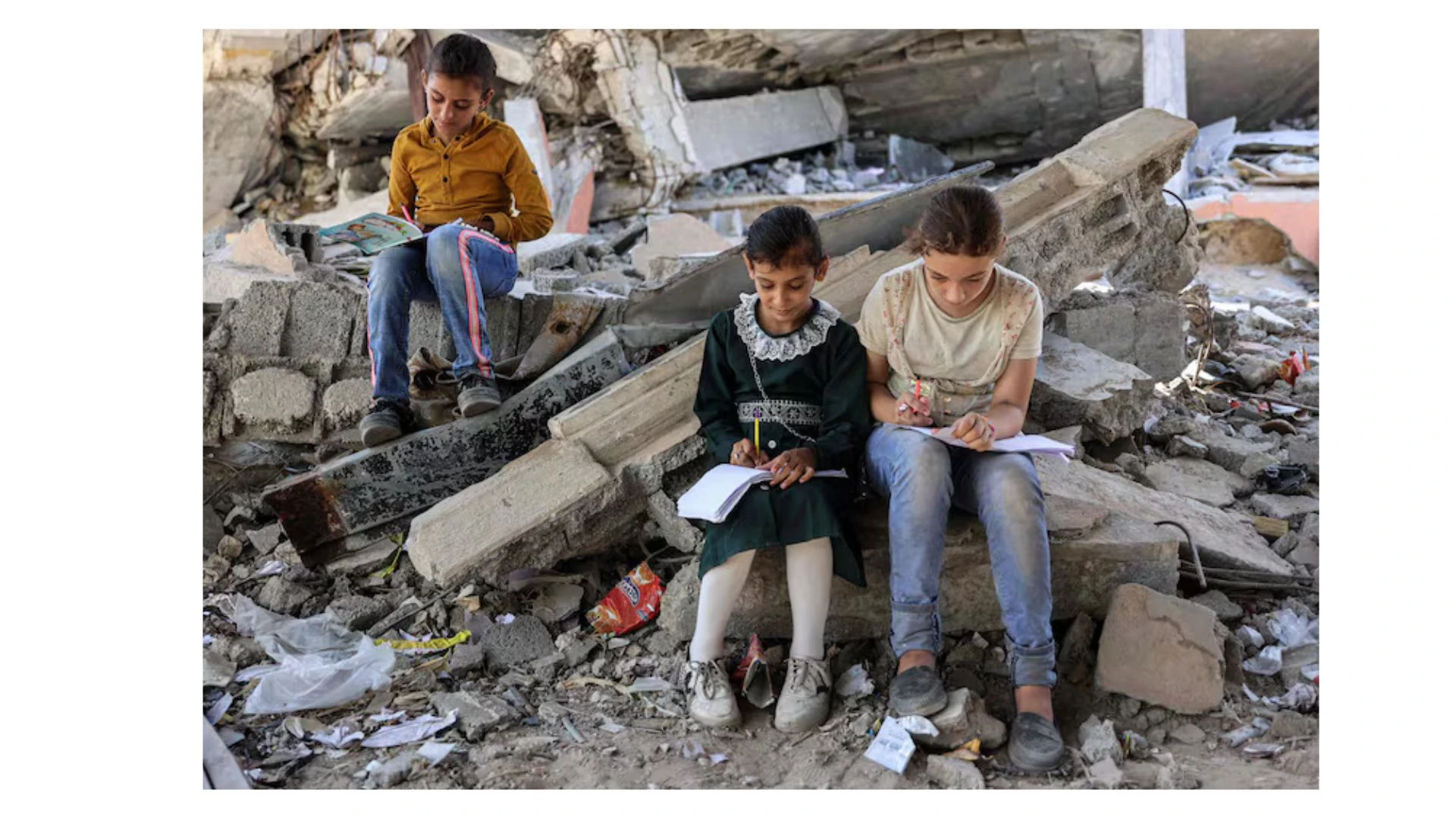 Anak-anak duduk di reruntuhan dekat tenda yang digunakan sebagai pusat pendidikan darurat di Jabalia, Gaza utara, pada 8 September 2024. (Kredit: Omar al-Qattaa/AFP)