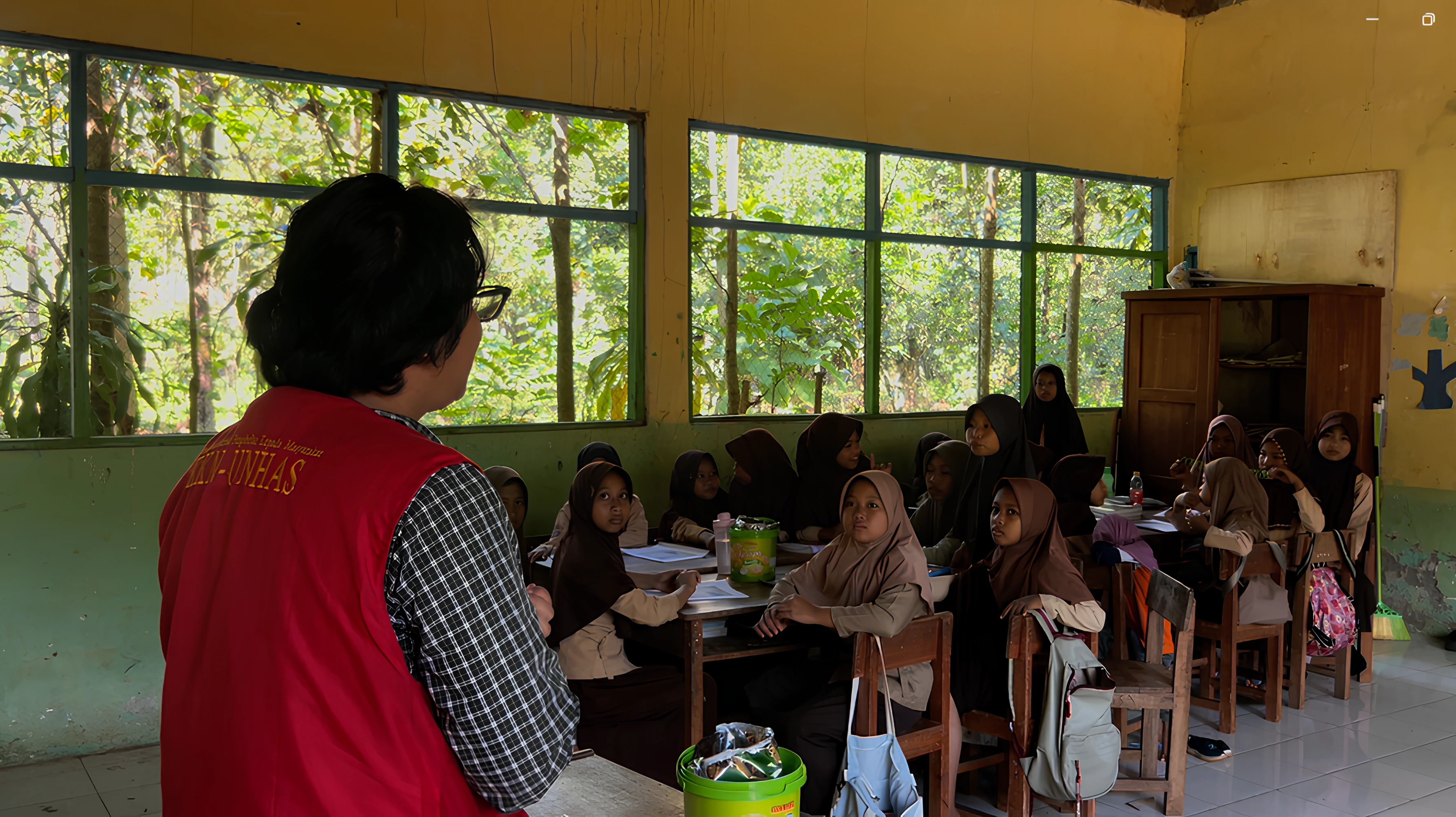 Mahasiswa Unhas membimbing siswa SD dalam program 