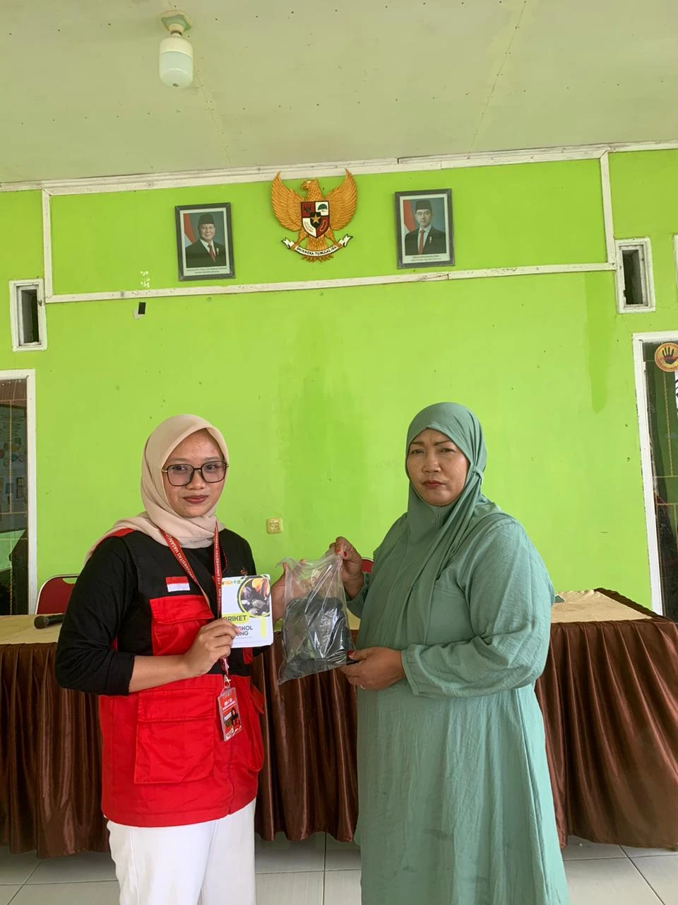 Penyerahan simbolis produk hasil olahan limbah jagung oleh mahasiswa KKN Unhas kepada Ibu Kepala Desa Bonto Loe. Aulia Muthara menyerahkan paket Briket Biomassa sebagai hasil dari pelatihan teknologi tepat guna.
