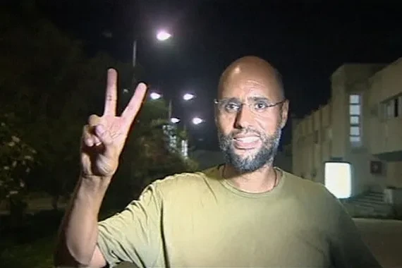 Saif al-Islam Gaddafi, putra mantan pemimpin Libya Muammar Gaddafi, memberikan tanda 'V' di Tripoli pada 23 Agustus 2011 (Kredit: Reuters).